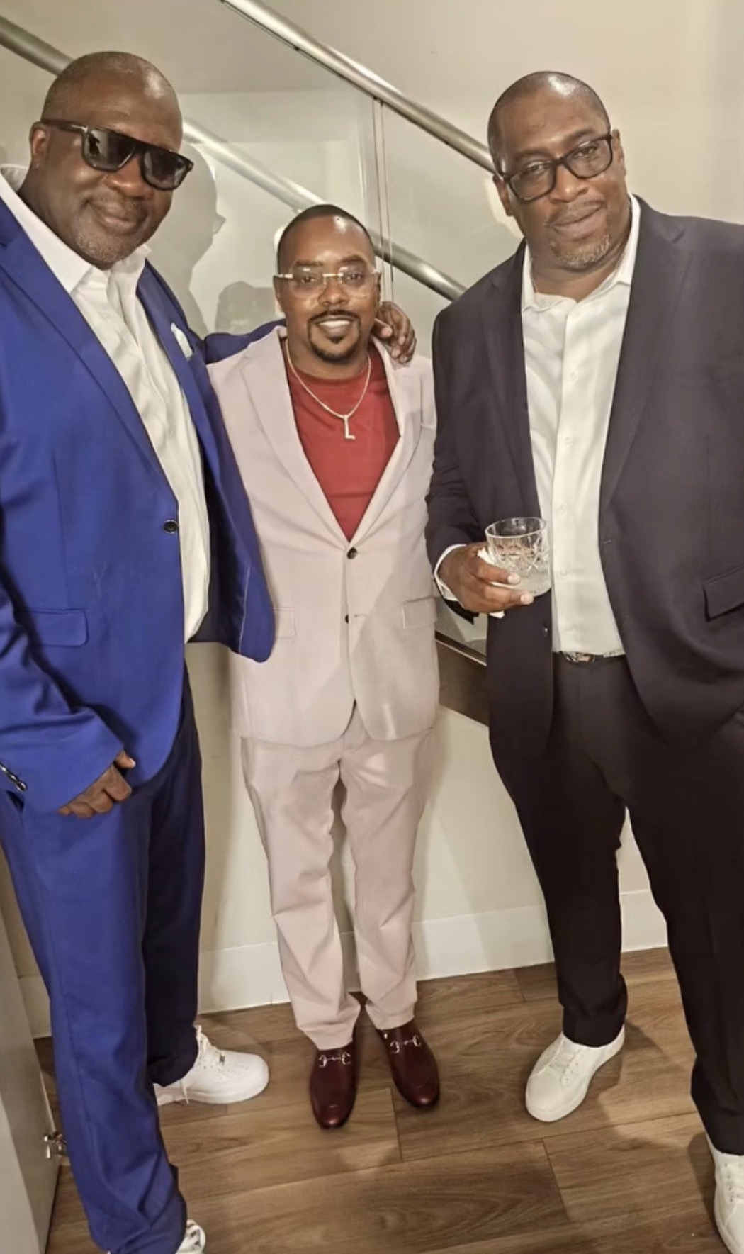 The three owners of House Of Petals 127 in suits at their Harlem flower shop